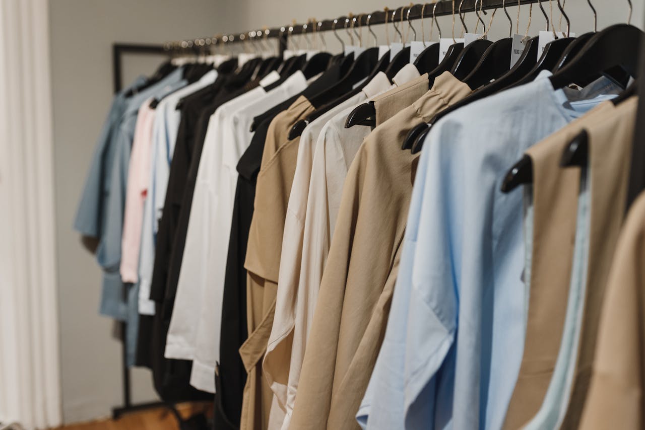 our-services-3 Stylish clothes hanging on a rack, showcasing a variety of elegant fashion pieces.