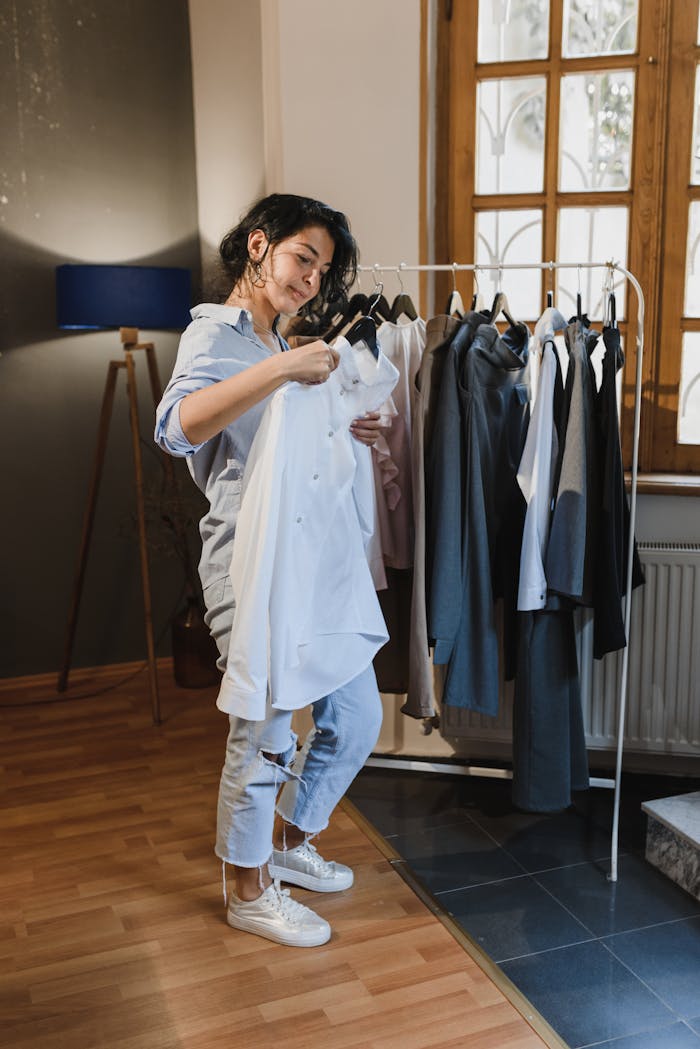 why-choose-us A woman browsing clothes on a rack in a stylish, well-lit boutique setting.